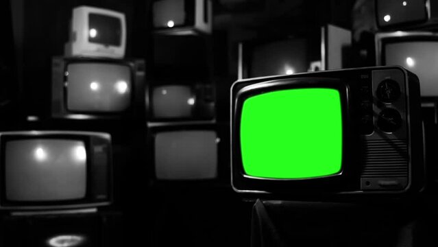 An Old Television Green Screen Among Many Retro TVs. Black and White. You can replace green screen with the footage or picture you want with “Keying” effect in After Effects.