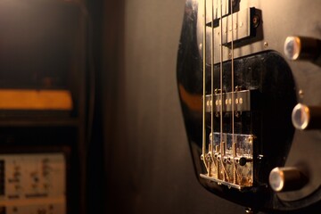 electric bass hanging on a black wall