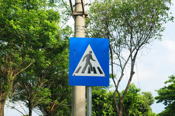 Blue and white pedestrian crossing sign on the road