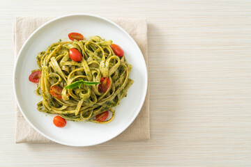 fettuccine spaghetti pasta with pesto sauce and tomatoes