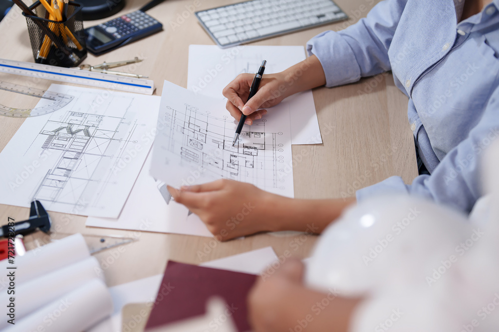 Poster two asian architect engineer discussion about drawing architecture plan project on blueprint while w