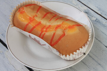 Jam filled bread in a paper cup on a white plate on the table

