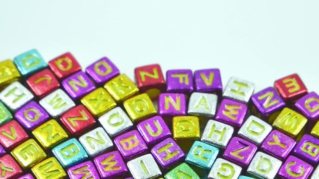 Multicolored alphablocks with english letters slow movement on a white background.