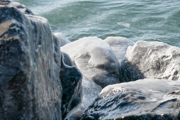Close up of Ice Covered Rocks Near Lake Shore