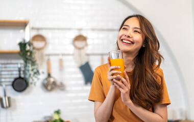 Portrait of beauty healthy asian woman making orange fruit smoothie with blender.girl preparing cooking detox cleanse with fresh orange juice in kitchen at home.health, vitamin c, diet, healthy drink