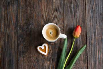 Fresh orange tulips and cappuccino mug with spring composition. Greeting card with copy space for Valentine's Day, Woman's Day and Mother's Day.