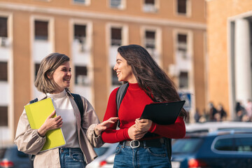 two student girls talking and smiling. Leaving class