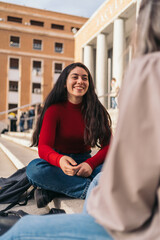 Two student girls sitting on the stairs of the college