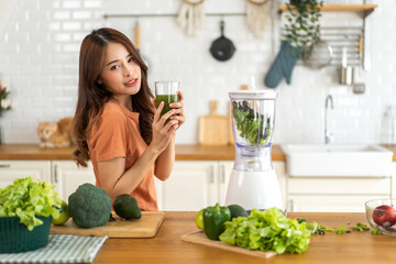 Portrait of beauty healthy asian woman making green vegetables detox cleanse and green fruit smoothie with blender.young girl drinking glass of smoothie, fiber, chlorophyll in kitchen.Diet, healthy - obrazy, fototapety, plakaty