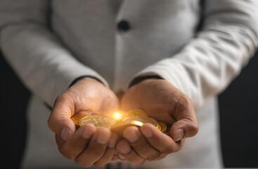 investment and finance concept, businessman holding money and blurred light on hand, stock market,...