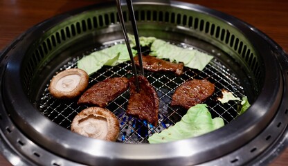 焼肉屋で網の上でキャベツ、椎茸、牛肉を焼いている様子