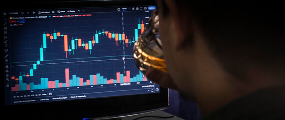 Man drinking while analyzing cryptocurrency stock charts