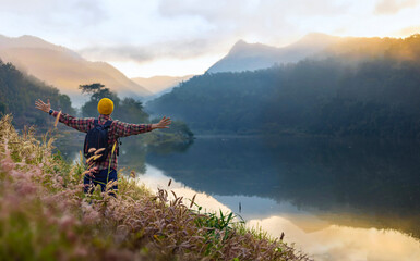 Asian naturalist hiking at destination while exploring wildlife in the forest by the lake for surveying and discovering the rare biological diversity and ecologist on field study in autumn