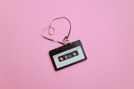 Heart Next to an Audio Cassette on a Colorful Pink Background. Beautiful design of romantic music old school mixtape concept 

