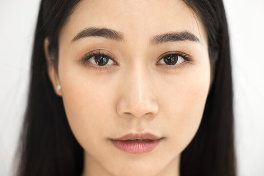 Beautiful female Asian beauty care models face front close up. Calm relaxed young Korean woman with soft clean perfect skin looking at camera, posing for cropped portrait