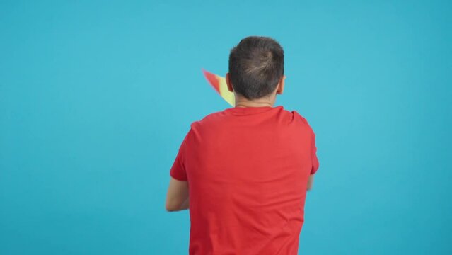 Rear view of a man waving a begian pennant