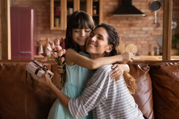 Happy holiday, dear mommy. Affectionate single latina mother hug tight beloved child preteen girl...