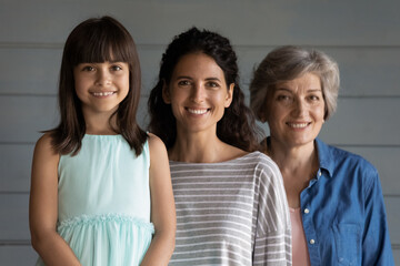 Three diverse women of hispanic family. Group portrait of adorable preteen kid girl daughter...
