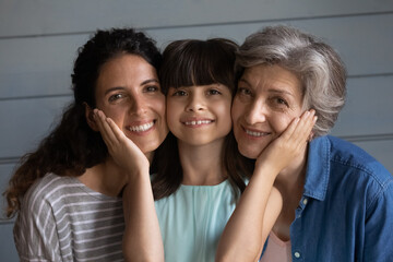 Tender relationship. Portrait of bonding multi generational family of older grandma young mom and...