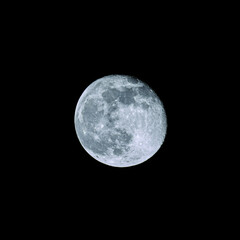 a waning full moon in the black night sky
