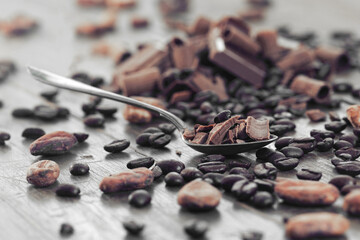 Broken dark chocolate and coffee beans on a table