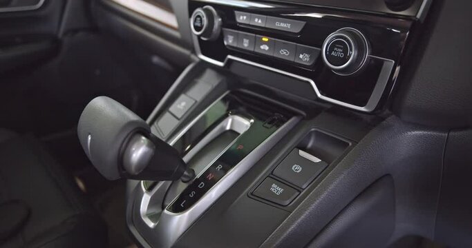 The driver engages in manual gear shifting, transitioning the automatic transmission through Park (P), Reverse (R), Neutral (N), and Drive (D) modes using hand-controlled mechanism in autometic car.
