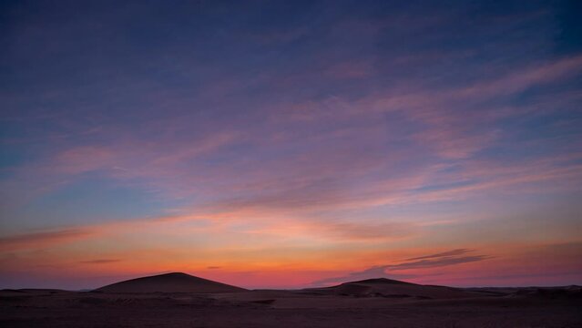 Day to night sunset time lapse in desert sand dune with beautiful clouds.