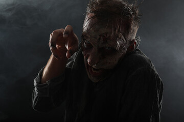 Scary zombie on dark background. Halloween monster