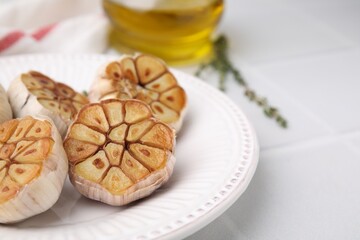 Heads of fried garlic on white table, closeup. Space for text