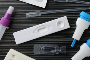 Disposable express test kits on black wooden table, flat lay