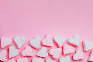 Pink marshmelow hearts on a pink background. The concept of Valentine's Day. February 14