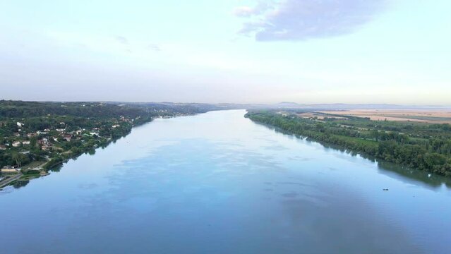 Drone descends and captures blue rippling water surface of Danube river in dawn