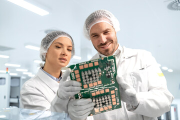 Engineering technologist holding printed circuit boards and developing electronics components.