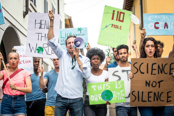 Public demonstration on the street against global warming and pollution. Group of multiethnic people making protest about climate change and plastic problems in the oceans - obrazy, fototapety, plakaty