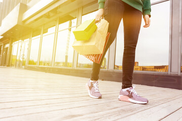woman in jeans and sneakers, with shopping bags