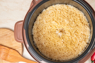 Just cooked pilaf with turkey, mutton, beef or pork, carrots, onions, garlic, pepper and raisin in the modern multicooker. A traditional dish of Asian cuisine.