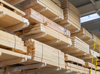 Wooden boards and slabs in the warehouse of the hardware store or in a construction hypermarket. Construction sheet materials stored on cantilever rack in joinery workshop. Sale of materials.