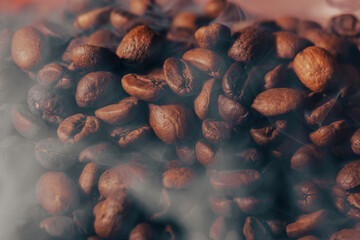 Roasted coffee beans with smoke and fire background. Close up,