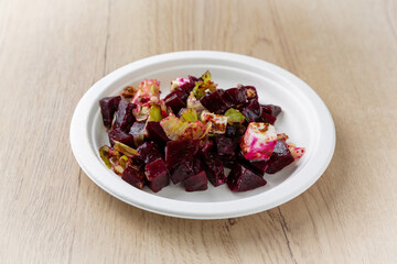 Beetroot salad with cheese. On a light wooden background.