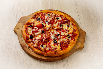 Meat pizza. On a light wooden background.