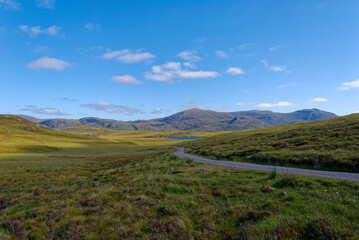 Fototapeta na wymiar A view of the North Lochs in the Central area of the Isle of Lewis. with a winding road running through the Remote Region.
