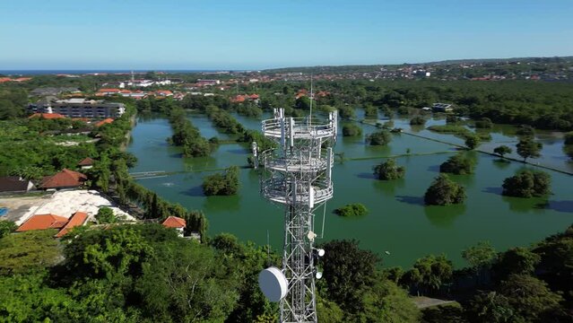 Drone flight around a cell tower. Antennas of a telecommunications tower against the backdrop of an Asian city.