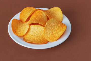 Round crispy potato chips on a brown background
