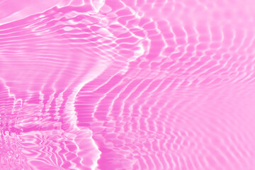 Purple water background. Pink water splashe on the surface ripple blur. Defocus blurred transparent pink colored clear calm water surface texture with splash and bubble. Water waves with shining.