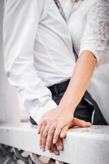 Close-up of a married couple holding hands on a railing. Valentine's Day. A young couple. Hands close up. Bottom view.