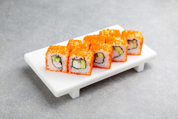 Japanese California Sushi roll with shrimp on a white stand, gray background