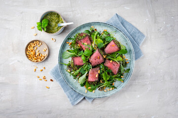Traditioneller gemischter Salat mit Spinat gefüllten Roastbeef Röllchen und Pinienkerne serviert...