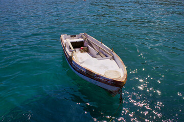 Fototapeta na wymiar Old Small Fishing Greek Boat on the coastline of Zeus Bay. Naxos, Greece. 