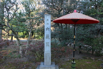 Fototapeta na wymiar Stone monument and traditional umbrella in Rikugien Garden, Tokyo, Japan (Japanese words mean the name of garden 
