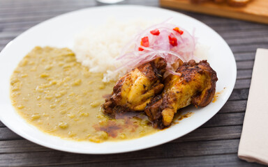 Chicken wings with mashed peas, rice and pickled onions on white plate